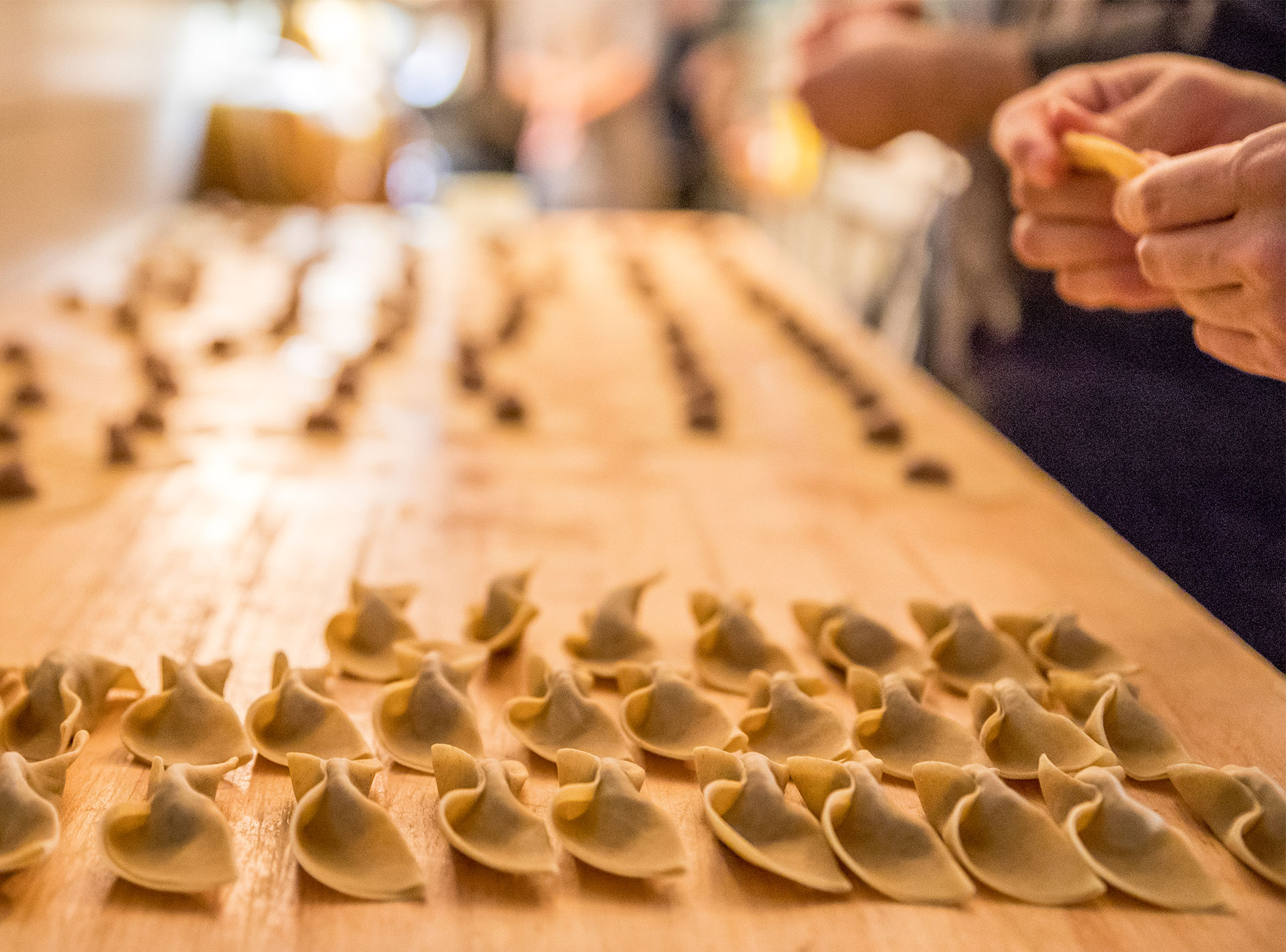 Handmade pasta being crafted at a wooden table in its fresh state